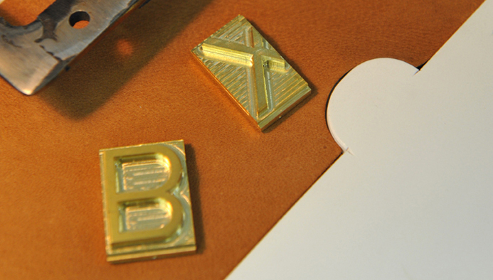 Si les initiales utilisées sont inspirées du marquage des bêtes dans les manades de Camargue, c'est Lucie Monin, doreuse d'art, qui se charge de graver à l'or 22 carats des motifs floraux, géométriques ou poétiques.